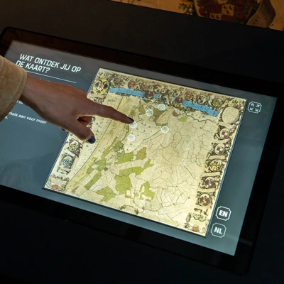 Close-up of a hand interacting with a digital map showing historical topography, part of an interactive display explaining the geography of Haarlemmermeer.