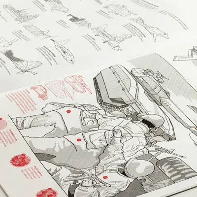 Close-up photograph of the printed atlas pages showing detailed black and red Risograph illustrations of military vehicles and equipment from the Camouflage chapter, with text annotations visible.