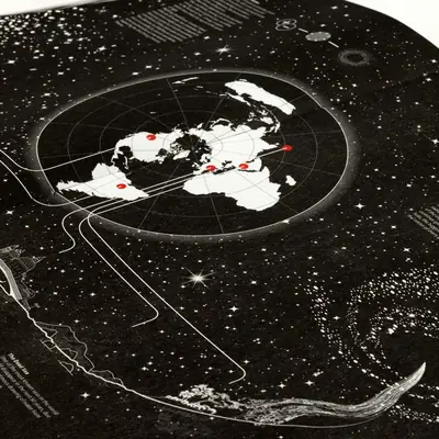 Close-up photograph of the printed Universe atlas spread, showing a polar projection Earth map with red location markers on a black starfield background, with orbital lines, a Dead Sea diagram, and a whale illustration in the lower portion.